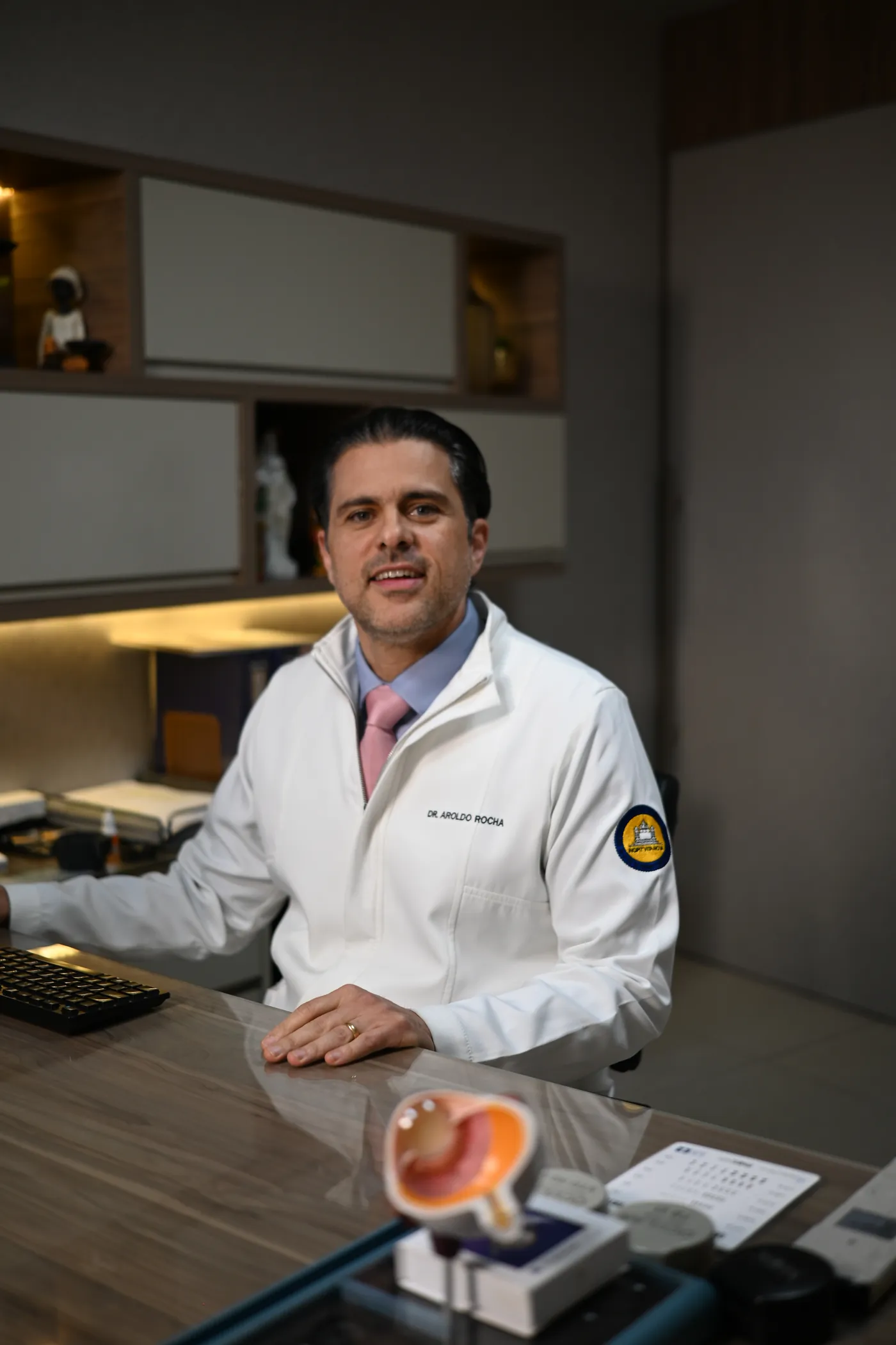 Dr. Aroldo Rocha em consultório oftalmológico, sorrindo